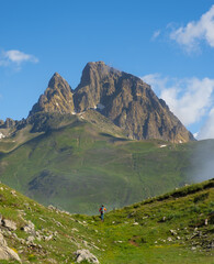 Fototapeta na wymiar Senderista caminando con el monte Midi d Ossau al fondo, Francia