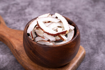 Dried coconut slices. Sliced dry coconut on dark background. Sun-dried fruit. close up