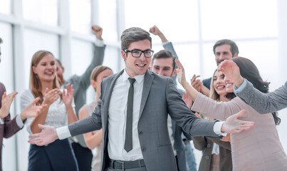 happy young businessman standing in front of his business team.