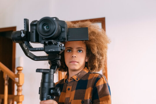 Boy with video camera at home