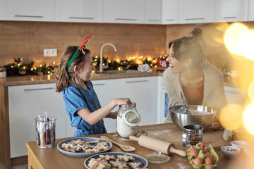 Happy mother and daughter enjoying baking time in kitchen