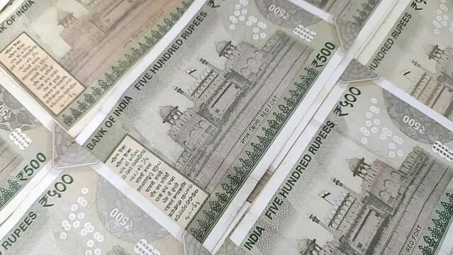 camera slowly sliding over heap of scattered five hundred rupee indian currency bank paper note cash or money. close up macro flatlay top view. inflation, value, foreign exchange or trade concept.