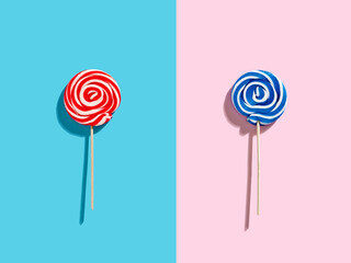 Red, blue and white colored swirl round candy lollipops on pink and blue duotone background.