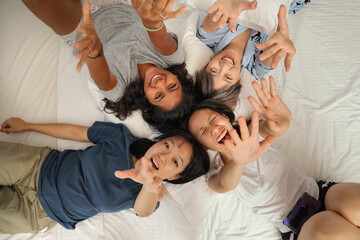 Young Asian girls sleepover pajama party happy joy funny laugh smile on large bed in bedroom with bright light window