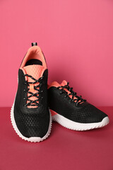 Pair of stylish sport shoes on pink background
