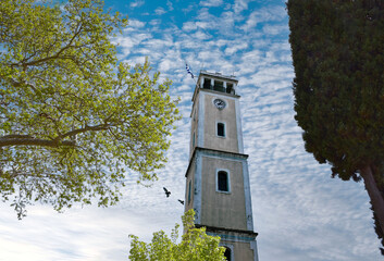 The clock tower of Komotini in Greece, Blue cloudy weather and birds.