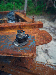 Close up of a rusted and burnt screw on a massage chair