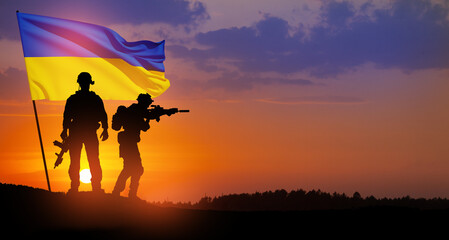 Fototapeta na wymiar Flag of Ukraine with silhouette of soldiers against the sunrise or sunset. Concept - armed forces of Ukraine. Relationship between Ukraine and Russia.