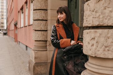 Close up view of brunette caucasian woman with backpack and smiling .