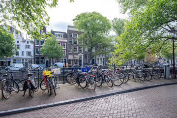 Fototapeta na wymiar Bike parked on a canal bridge. Amsterdam traditional façade house background, Netherlands Holland