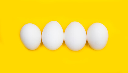 white chicken egg isolated on yellow background.