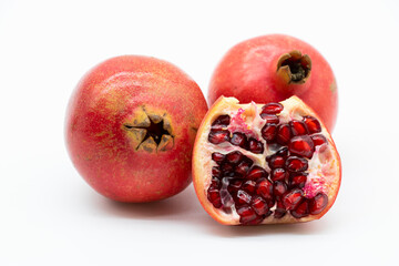 Fresh whole and half of pomegranate isolated on white background.