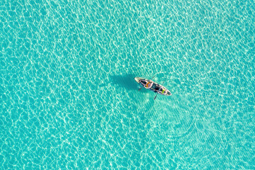 Fototapeta premium Summer vacation fun, sport activity. Men on Canoe kayak in turquoise blue Aegean Sea, aerial view.