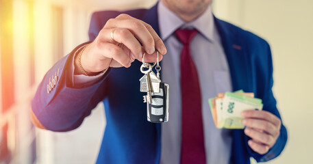 business man hold car and house key with euro money
