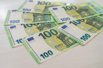 beautiful new 100 euro banknotes laid out on a spacious table