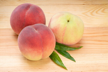 Pink and yellow Peach fruit with leaf on white background, Fresh Sweet Peach on wooden basket.