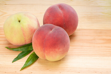 Pink and yellow Peach fruit with leaf on white background, Fresh Sweet Peach on wooden basket.