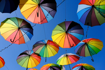 Fototapeta na wymiar Street decoration from rainbow color hanging umbrellas
