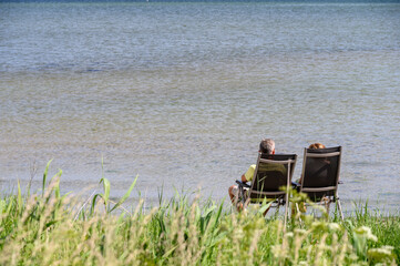 Fototapeta na wymiar Zwei Personen im Liegestuhl schauen auf das Meer