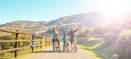 Fototapeta family riding on mountain bike (mother, father and children) obraz