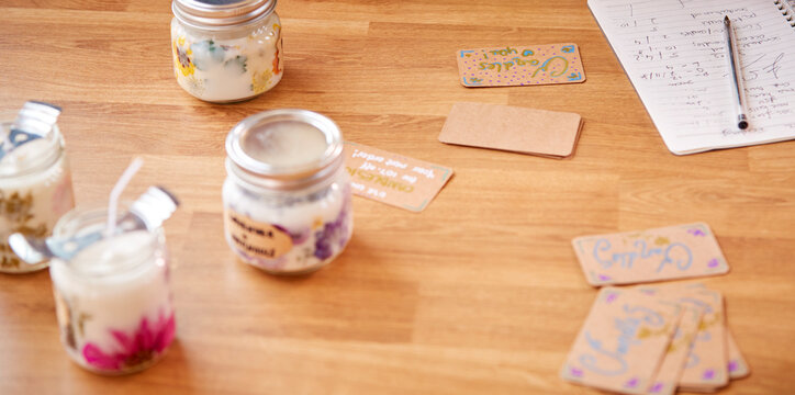 Close Up Of Homemade Boutique Candles With Handwritten Labels And Vouchers
