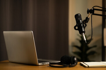 Desk of host streaming radio podcast at home broadcast studio.Such as laptop condenser microphone and headphone on table. Recording host streaming radio podcast interview conversation at home