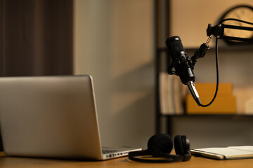 Obraz na płótnie Canvas Desk of host streaming radio podcast at home broadcast studio.Such as laptop condenser microphone and headphone on table. Recording host streaming radio podcast interview conversation at home