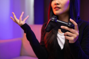 Boring Young pretty asian woman in hoodie playing game online. Japanese female Gamer holding joystick play video game online at home feeling sadness. Loss and Missed the chance to become a champion.