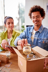 Young Couple Running Online Business From Home Packing Boutique Candles Ready For Shipping