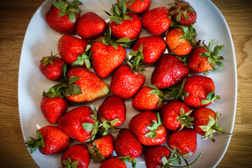 Strawberries on plate, wooden table