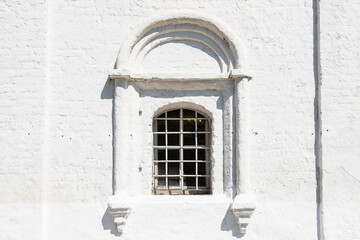 Fototapeta na wymiar grille window in wall of ancient russian church
