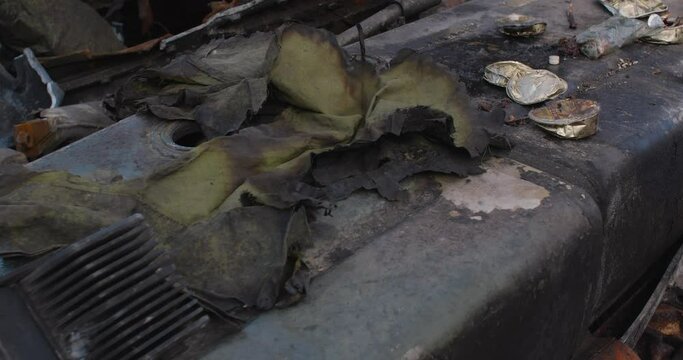 Close-up detailed tracking shot of the armor of a burnt-out Russian tank. Exibition in Kyiv on Sophia Square The uniform of the killed soldier, dry rations and canned food destroyed by the explosion