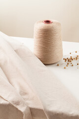 folded linen cloth with linen thread bobbins on table.