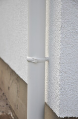 Close up on roof gutter downspout pipe holder on the house facade wall.