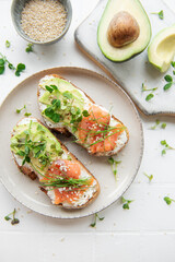 Sandwiches with salted salmon,  avocado and microgreens.