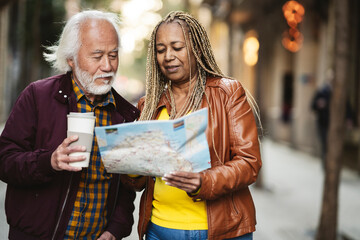 multiracial senior couple traveling in the city with a map, pretty seniors traveling retirees - Powered by Adobe