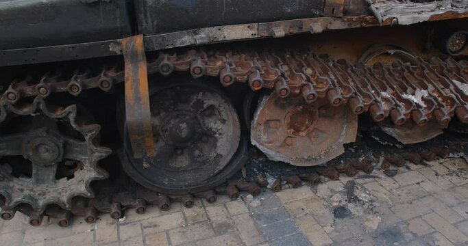 Close-up detailed tracking shot -  caterpillar  track of a burnt-out Russian tank t-72. Exibition in Kyiv on Sophia Square  Military vehicle destroyed by the explosion of Ukrainian artillery shelling