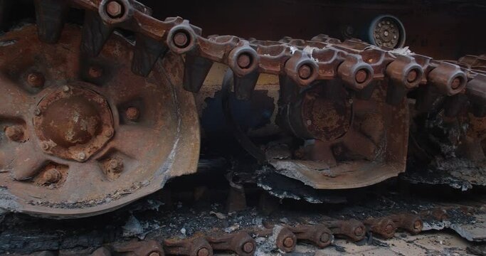 Close-up detailed tracking shot -  caterpillar  track of a burnt-out Russian tank t-72. Exibition in Kyiv on Sophia Square  Military vehicle destroyed by the explosion of Ukrainian artillery shelling
