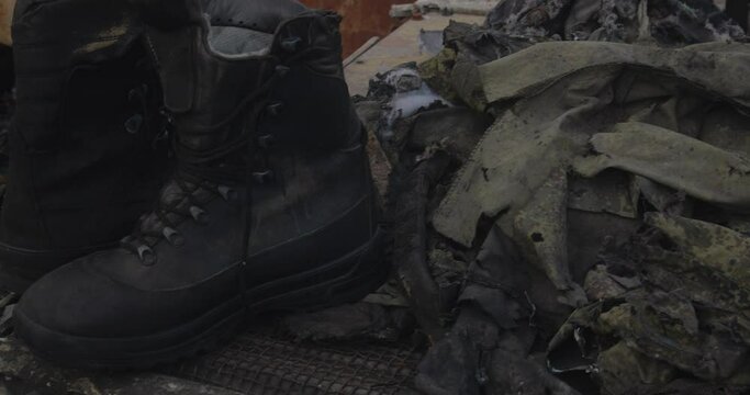 Close-up detailed tracking shot of the armor of a burnt-out Russian  airborne combat vehicle. Exibition in Kyiv on Sophia Square The uniform of the killed soldier  destroyed by the explosion