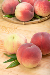 Fototapeta na wymiar Pink and yellow Peach fruit with leaf on white background, Fresh Sweet Peach on wooden basket.