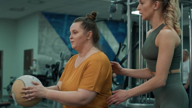 Caucasian woman with overweight doing training with fitness instructor at the gym. Shot with RED helium camera in 4K. 
