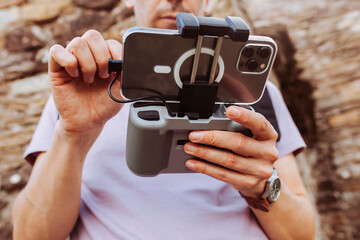 Close up portrait of operator hands holding and using remote controller of drone and smartphone. Technology concept.