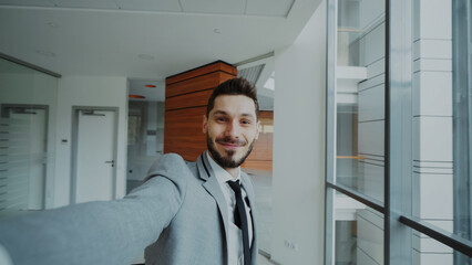 POV of young businessman in suit taking a selfie photo and have fun in modern office indoors