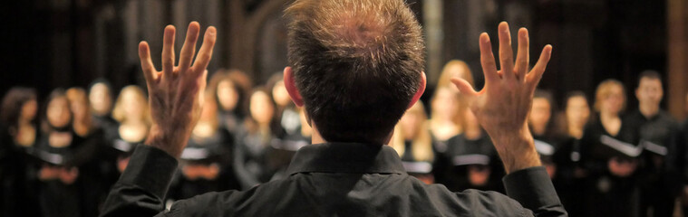 Musician leads a choir during a concert in a cathedral. Musical rehearsals before the concert...