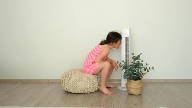 The girl is a child of 6 years old, Caucasian, she is very hot and the girl uses a fan.