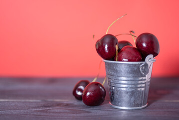 Cherry in a bucket on a dark and red background.