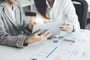 young Asian businesswoman using tablet computers to plan marketing strategies and invest to profit from customers