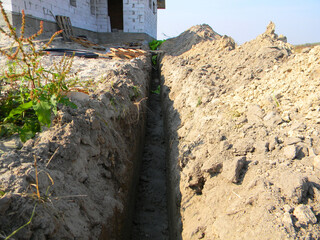 Digging a ground trench for house sewer pipes. Earthworks, digging trench to lay pipe or optical...