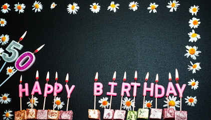 Happy birthday background with number   50. Copy space. Pink happy birthday candles on a black...