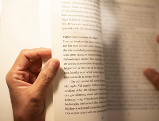 The image of the hand of a person holding a book and reading to learn.